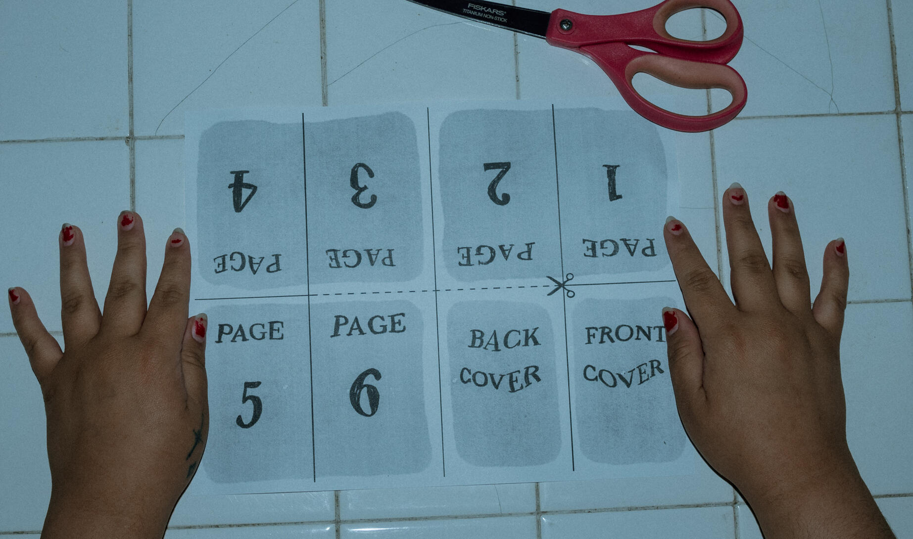 A digitally collaged photo of Toni PNW facing left and holding a small version of herself in cupped hands. The top says "About Me" in a light pink wavy font. At the bottom a polaroid One Step camera, a Mexican flag, and a 90's Furby are in a row.